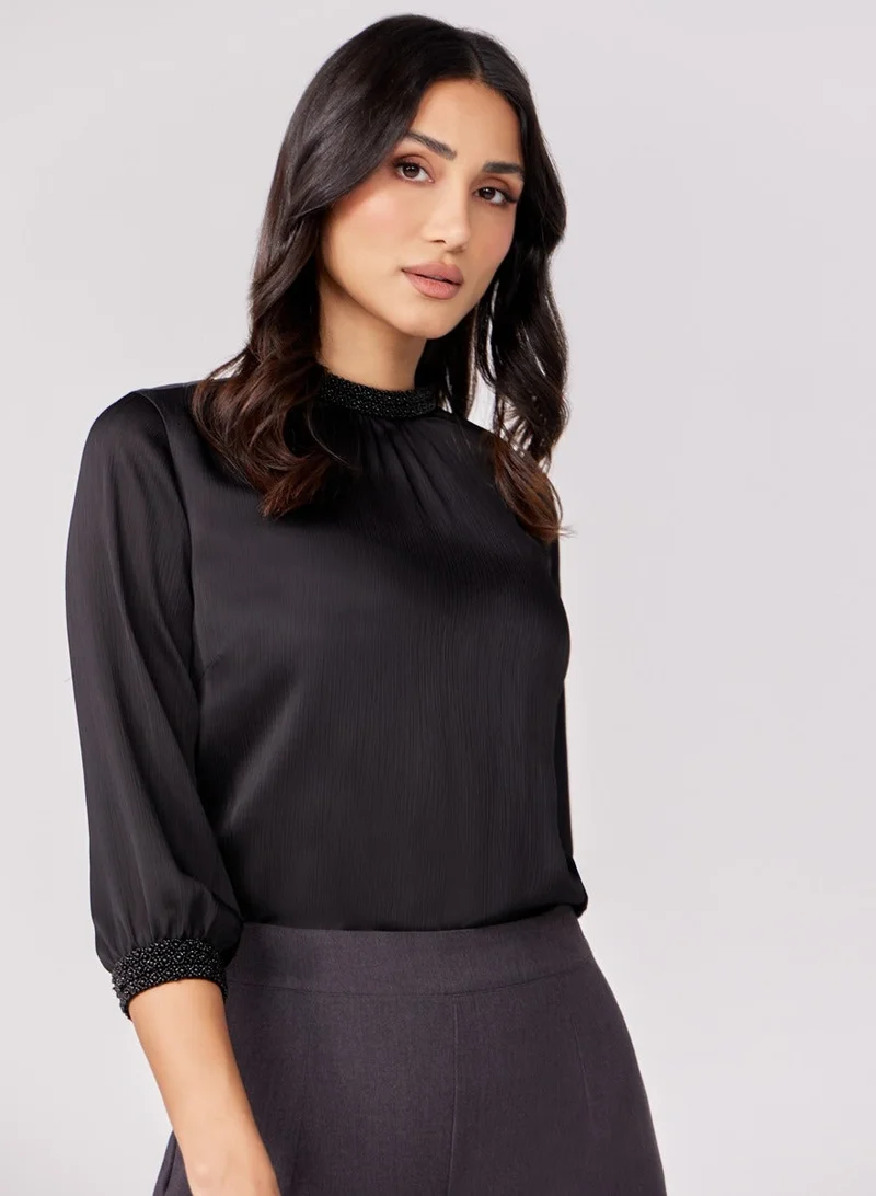 زجزاج بلوزة سوداء ذات أكمام ثلاثة أرباع مع تطريز مرفق